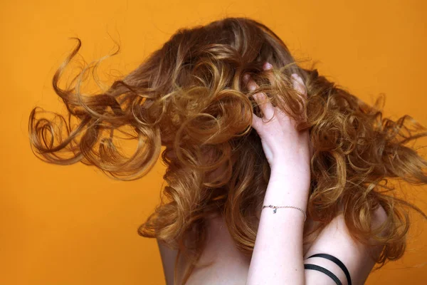 Bella ragazza dai capelli rossi con lussuosi capelli ricci. Studio ritratto su sfondo giallo. Capelli eccellenti — Foto Stock