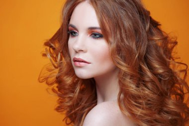 Lüks kıvırcık saçlı güzel kızıl saçlı kız. Stüdyo portre Sarı zemin üzerine. Mükemmel saç