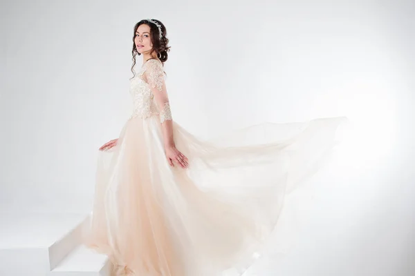 Portréja egy gyönyörű lány, egy esküvői ruha. Menyasszony egy fényűző ruhát, állva a lépcsőn felmászni — Stock Fotó