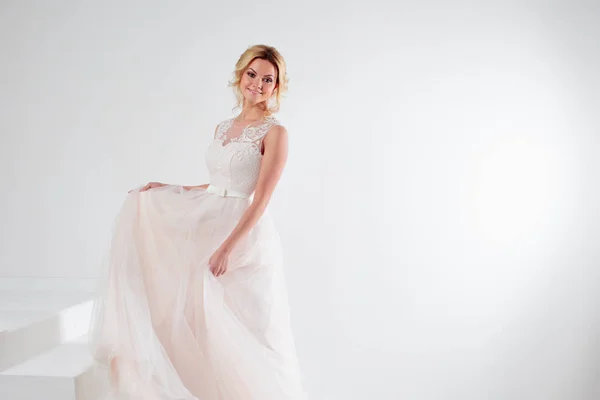 Portret van een mooi meisje in een trouwjurk. Bruid, witte achtergrond, vrije ruimte aan de rechterkant — Stockfoto