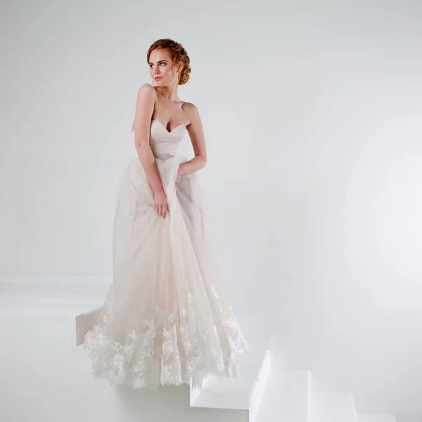 Retrato de uma menina bonita em um vestido de noiva. Noiva em vestido de luxo em um fundo branco — Fotografia de Stock