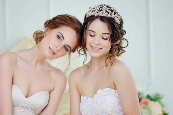 Due ragazze in abiti da sposa. Belle ragazze delicate nel salone da sposa — Foto Stock