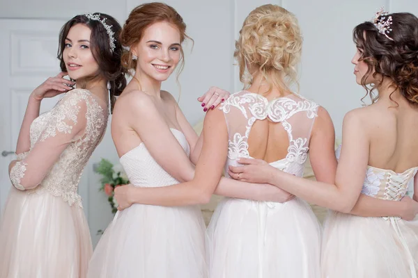 Sposa in salone nuziale. Quattro belle ragazze sono tra le braccia. Indietro, primo piano gonne di pizzo — Foto Stock