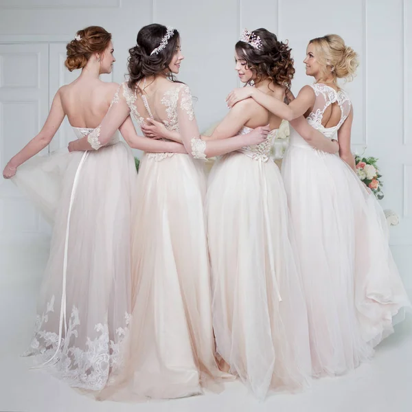 Gelin düğün salonda. Dört güzel kız çoğu birbirimizin kollarında. Arka kapağı transparan, yakın çekim dantel etek — Stok fotoğraf