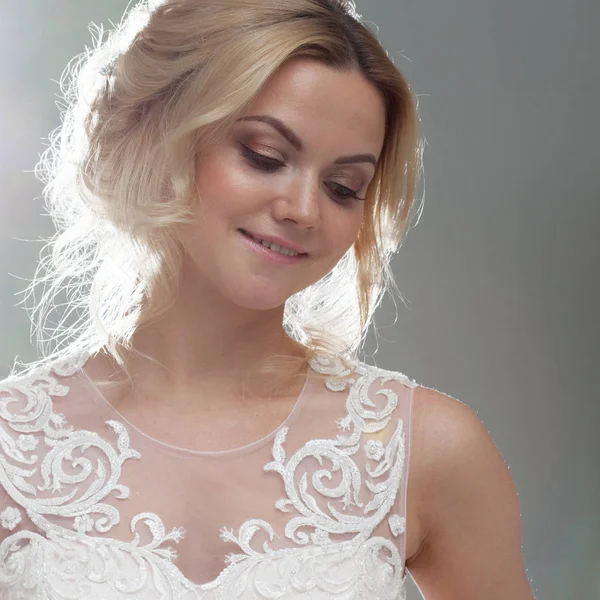 Portret van een mooi meisje in een trouwjurk. Bruid in een luxe jurk op een witte achtergrond, close-up — Stockfoto