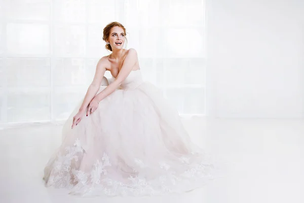 Портрет красивой девушки в свадебном платье. Невеста в роскошном платье сидит на стуле — стоковое фото