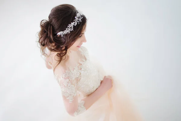 Dancing beautiful girl in a wedding dress. Bride in luxurious dress on a white background — Stock Photo, Image