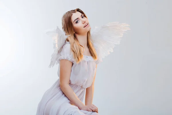 Un angelo dal cielo. Giovane, meravigliosa ragazza bionda a immagine di un angelo con le ali bianche. Ritratto primo piano — Foto Stock