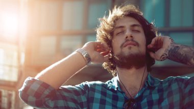 Sakallı adam müzik keyfi. Genç yakışıklı şık adam sokakta portresi.