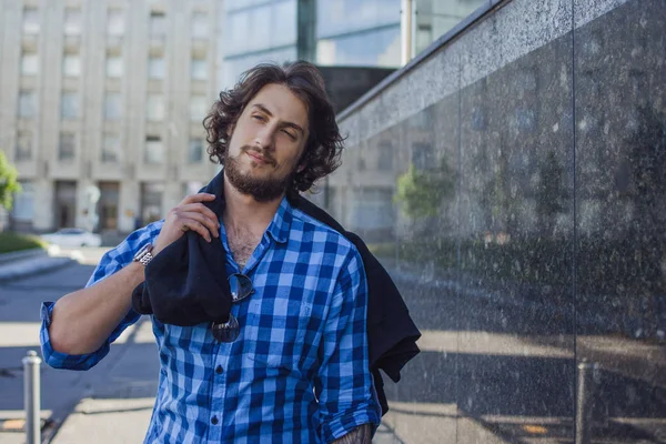 Retrato de un joven guapo y elegante en la calle. El tipo de la camisa azul — Foto de Stock