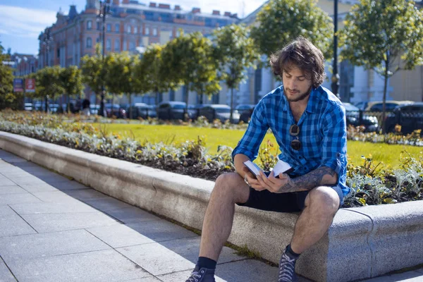 Joven leyendo libro en la calle, al aire libre día soleado — Foto de Stock