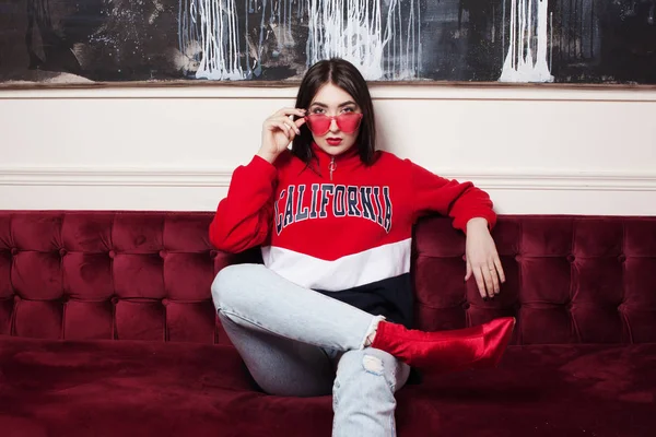 Mujer joven de moda ia una sudadera con capucha roja. Retrato en el interior de moda . —  Fotos de Stock