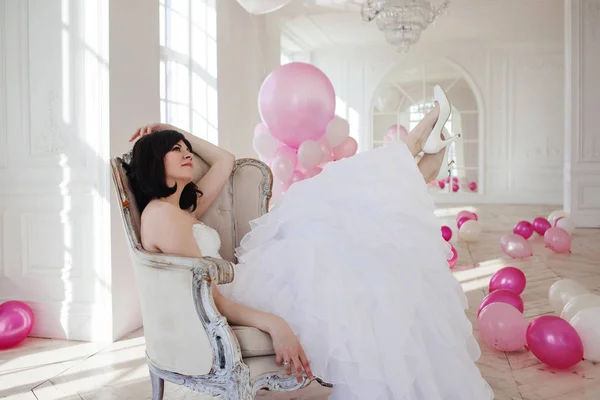 Mujer joven en vestido de novia en el interior de lujo con una masa de globos de color rosa y blanco . — Foto de Stock