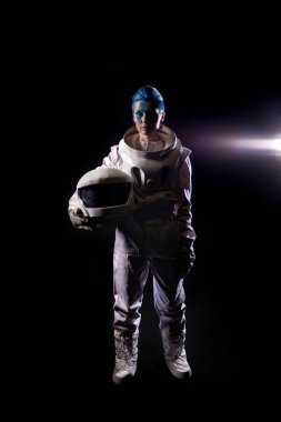 Siyah bir arka plan yüz sanat uzay giysisi içinde olan bir genç kadın astronot. Kask elinde