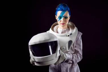Siyah bir arka plan yüz sanat uzay giysisi içinde olan bir genç kadın astronot. Kask elinde