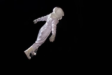 Ağırlıksız boşlukta yüzen astronot. Siyah arka plan, metin veya tasarım için yer