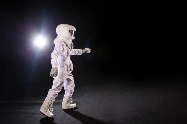 Astronot siyah bir zemin üzerine ileri gider ve bir yere el uzanır — Stok fotoğraf