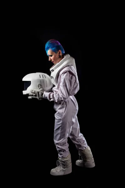 Астронавт на чорному тлі, молода жінка з мистецтвом обличчя в космічному костюмі. Переходить ліворуч — стокове фото