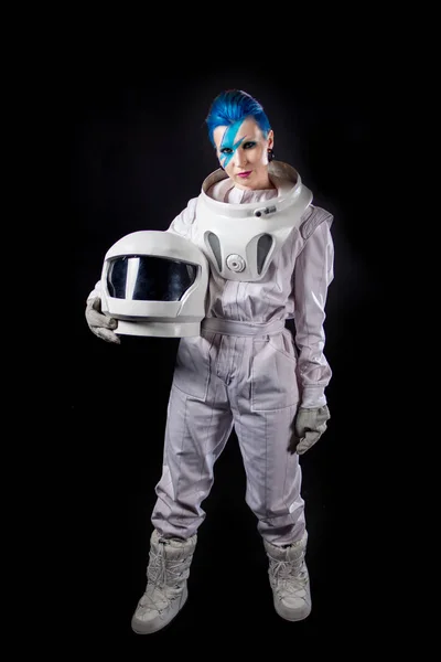 Astronauta sobre um fundo preto, uma jovem com arte facial no traje espacial. Capacete nas mãos — Fotografia de Stock