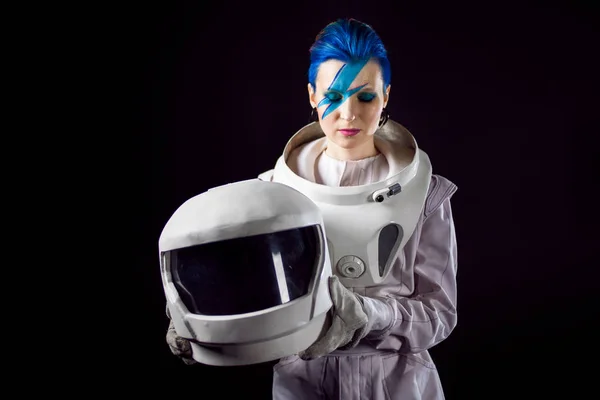Astronauta na czarnym tle, młoda kobieta o twarzy sztuki w skafander kosmiczny. Kask w ręce — Zdjęcie stockowe