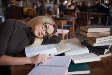 Üniversite öğrencisi yorgun genç kadın. Sınav hazırlama ve Halk Kütüphanesi derslerde öğrenme.