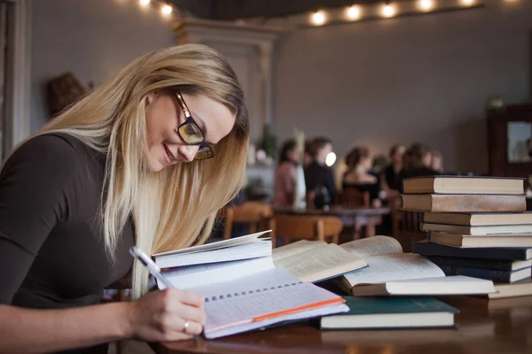 Fiatal nő tanul, örömmel. Felkészülés a vizsgára, és a tanulságok a nyilvános könyvtár. — Stock Fotó