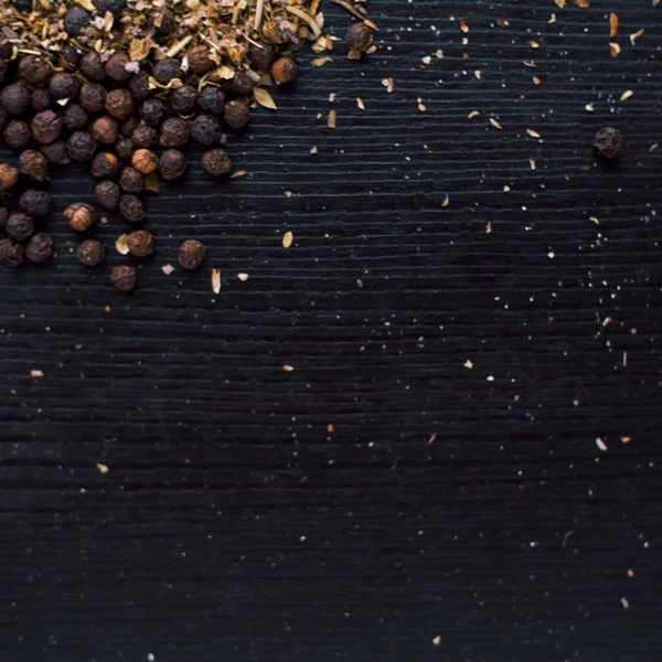 Pimienta negra y roja, granos y especias molidas. Colocador en la mesa — Foto de Stock