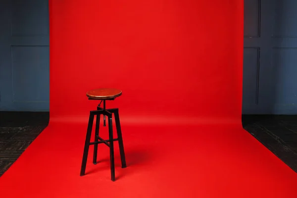 Tabouret rétro en bois sur fond rouge. Personne, espace libre à droite . — Photo