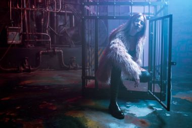 Şık giysileri ile genç çekici kadın. Kabarık pembe kürk ceket, cyberpunk arka plan güzel kız. Neon ışık