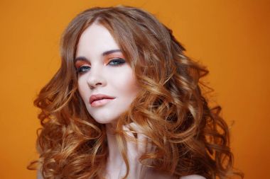 Lüks kıvırcık saçlı güzel kızıl saçlı kız. Stüdyo portre Sarı zemin üzerine. Mükemmel saç