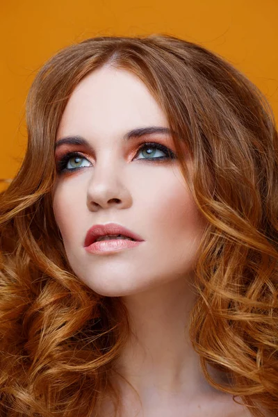 Lüks kıvırcık saçlı güzel kızıl saçlı kız. Stüdyo portre Sarı zemin üzerine. Mükemmel saç — Stok fotoğraf