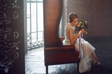 Buket çiçek ile gelinlik içinde genç güzel kadın. Düğün saç modeli, saç çiçekleri.