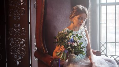 Buket çiçek ile gelinlik içinde genç güzel kadın. Düğün saç modeli, saç çiçekleri.