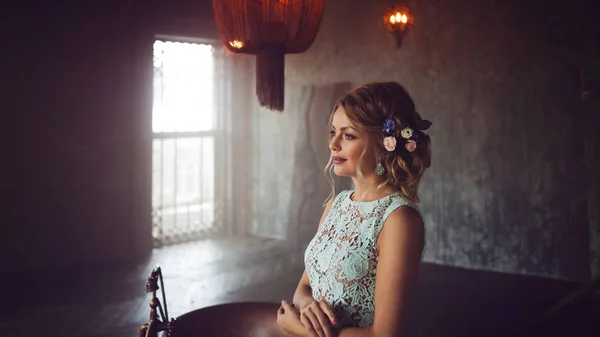 Young woman in lace dress and her hair decorated with flowers. — Stock Photo, Image