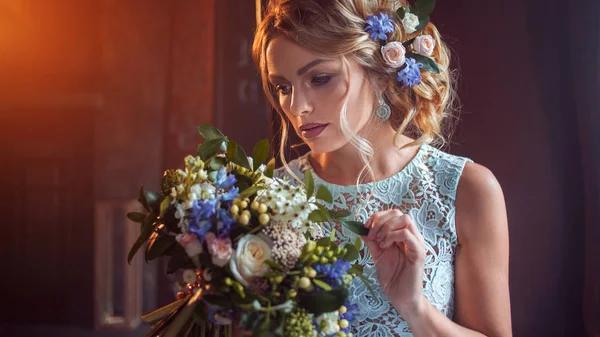 Joven mujer hermosa en vestido de novia con ramo de flores. Peinado de boda, flores en el pelo . — Foto de Stock