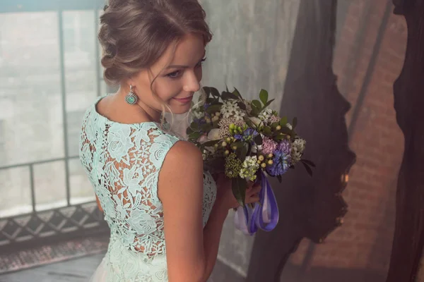 Ung vacker kvinna i brudklänning med bukett blommor. Bröllop frisyr, blommor i håret. — Stockfoto