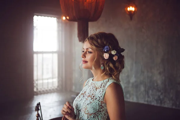 Mujer joven en vestido de encaje y su cabello decorado con flores . — Foto de Stock