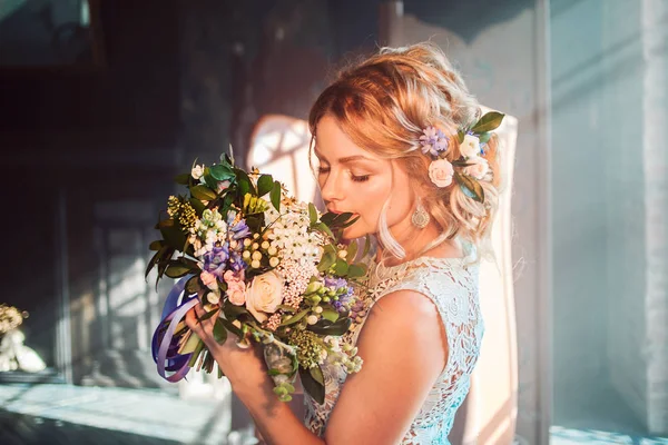 Buket çiçek ile gelinlik içinde genç güzel kadın. Düğün saç modeli, saç çiçekleri.