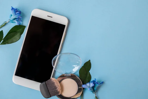 Cosmetica en Smartphone, vrouwen stijl, blauwe achtergrond instellen — Stockfoto