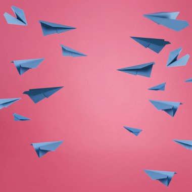 Mavi kağıt uçaklar pembe bir arka plan üzerinde bir sürü.