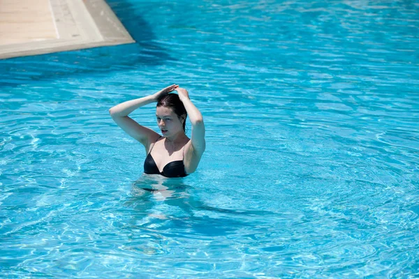 Gelukkig meisje zwemmen in een zwembad — Stockfoto