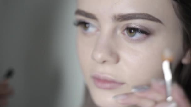 Visagist oog make-up doen. Jong meisje doet professionele make-up, oogschaduw — Stockvideo