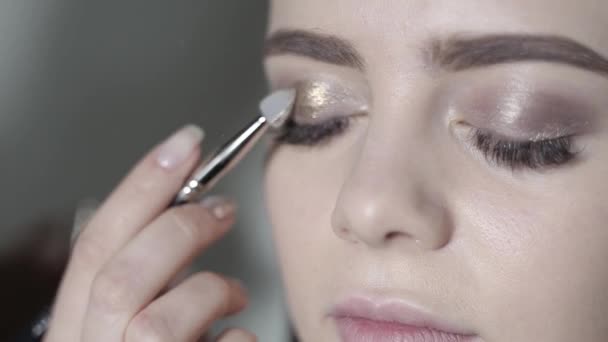 Visagist oog make-up doen. Jong meisje doet professionele make-up, oogschaduw — Stockvideo