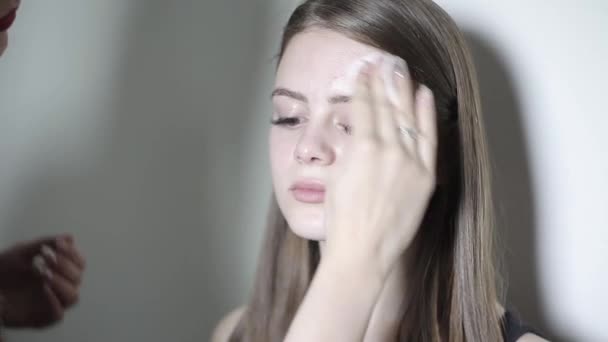 Maskenbildner legt eine klangliche Basis an. junges Mädchen beim Schminken — Stockvideo