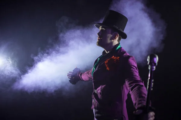 Showman. Joven artista masculino, presentador o actor en el escenario. El tipo de la camiseta púrpura y el cilindro . — Foto de Stock