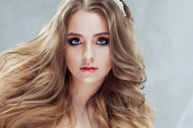 Lüks bukleler ile genç güzel gelin. Taç düğün saç modeli.