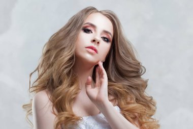 Lüks bukleler ile genç güzel gelin. Taç düğün saç modeli.