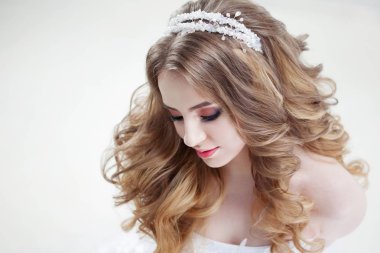 Lüks bukleler ile genç güzel gelin. Taç düğün saç modeli.