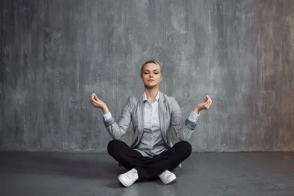 Mulher jovem em terno de negócios sentado em pose de lótus, restaurar a energia, meditar. Saúde e trabalho — Fotografia de Stock