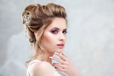 Zarif bir yüksek saç modeli ile genç güzel gelin. Düğün saç modeli ile saçında Aksesuar